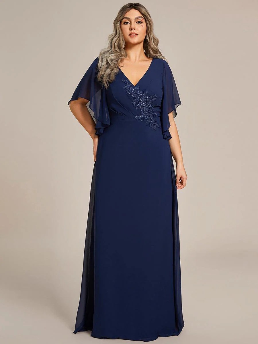 Lorie A graceful chiffon A-line Mother of the Bride dress featuring soft flutter ruffle sleeves and delicate appliqué detailing for an elegant finish. This dress is not currently in stock but is available to order.
