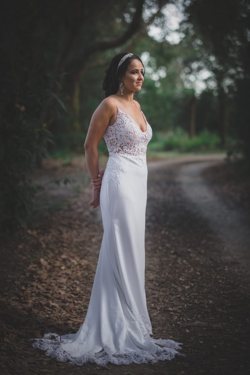 samantha Crepe & Lace Sheath Bridal Gown with Long Lace Train The Samantha gown is an effortlessly elegant choice for the bride who loves clean lines with soft, romantic detail. Crafted from luxurious crepe and delicate lace, this gown is designed to create a timeless silhouette with modern refinement. ✨ Design Highlights: ✔ V-Neckline Bodice – Flattering and feminine with a sheer lace overlay. ✔ Thin Straps – Delicate and minimal, perfect for a light and airy bridal look. ✔ Sheer Lace Bodice – Adds intricate texture and soft sensuality. ✔ Low Open Back – Finished with a row of buttons for a touch of classic bridal charm. ✔ Fitted Sheath Silhouette – Smooth and body-skimming for a sleek, contemporary shape. ✔ Long, Lace-Edged Train – Romantic and dramatic, ideal for a grand aisle entrance. 💫 Customization Options: ✅ Available in standard sizes or tailored to your exact measurements ✅ Option to adjust neckline, strap style, or train length ✅ Can be made in off-white or white crepe and lace ✅ Add a detachable overskirt or sleeves upon request 👑 A gown for the bride who desires understated luxury with a romantic edge. Perfect for a chic, graceful walk down the aisle. 👑 📞 Book your bridal fitting today! 📧 info@bestersbridal.co.za | 📱 084 268 1354