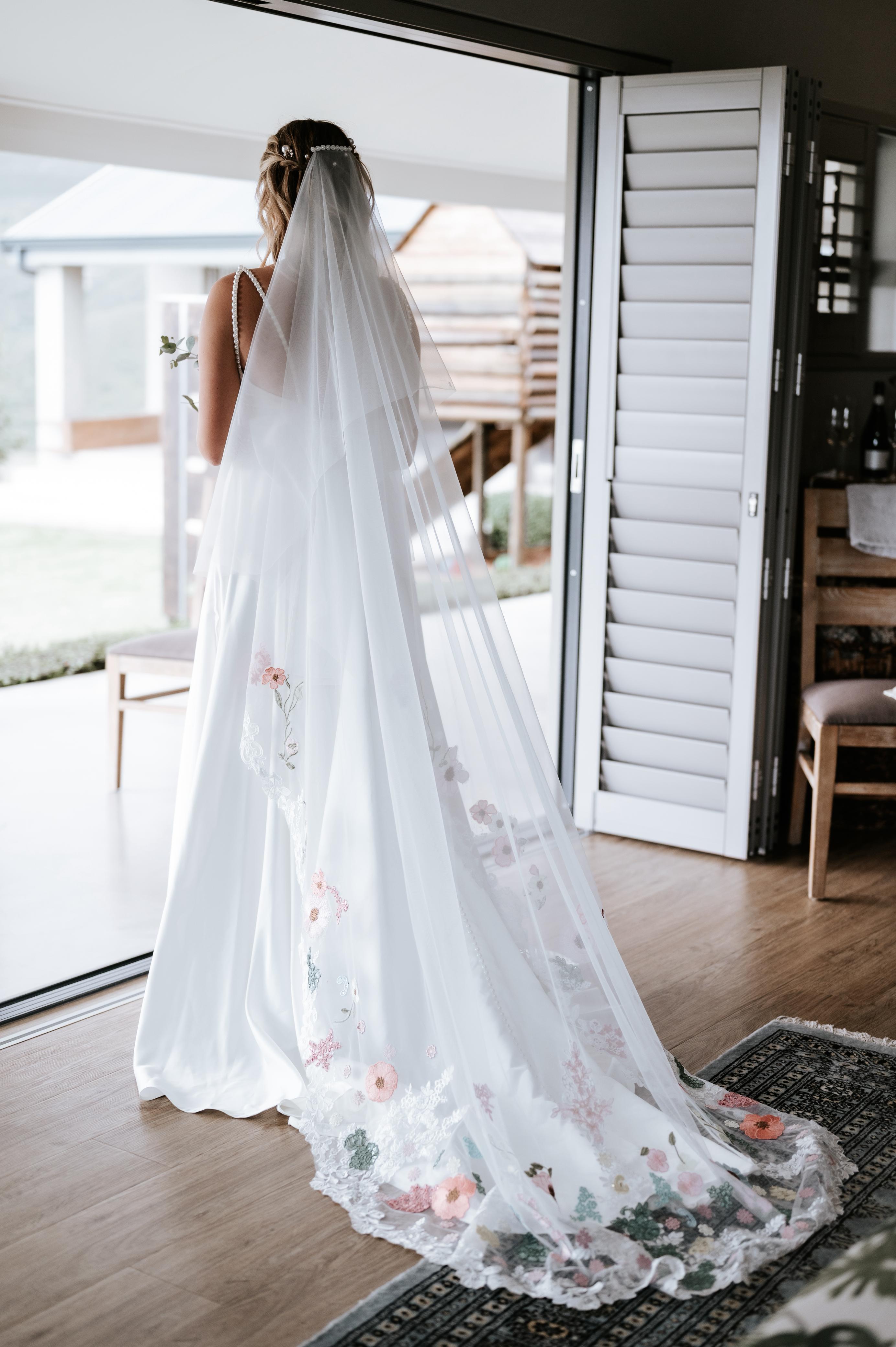 maryke Ruched Satin A-Line Wedding Gown with Pearl Strap Detail The Maryke gown is a graceful fusion of classic satin elegance and modern detailing. With its soft scoop neckline and romantic ruching, this design flatters the figure while highlighting feminine charm. Pearl-beaded straps add a timeless, luxurious touch, while the open back creates a striking silhouette from behind. ✨ Design Highlights: ✔ Scoop Neckline with Ruched Satin Bodice – Soft, flattering ruching that contours beautifully to the bust and waist. ✔ Delicate Pearl Straps – A refined accent that adds just the right touch of glam and bridal shimmer. ✔ Low Open Back Bodice – Modern and bold, balanced by the softness of the front. ✔ Nude Tulle Side Inserts – Lightly sheer panels under the arms for added comfort and subtle allure. ✔ Full-Flare A-Line Skirt with Pockets – A romantic and structured silhouette that allows for both elegance and ease. ✔ Long Flowing Train – Adds breathtaking movement and timeless drama as you walk down the aisle. 💫 Customization Options: ✅ Custom sizing tailored to your body shape ✅ Option to adjust neckline, back height, or trail length ✅ Satin available in off-white or ivory tones ✅ Option to add matching veil or pearl-trimmed accessories 🌸 Maryke is for the bride who dreams of timeless elegance, soft shine, and graceful femininity—perfectly blended in one unforgettable gown. 🌸 📞 Book your custom consultation today! 📧 info@bestersbridal.co.za | 📱 084 268 1354 Satin A-Line • Scoop Neck • Pearl Straps • Low Back • Pockets • Long Train