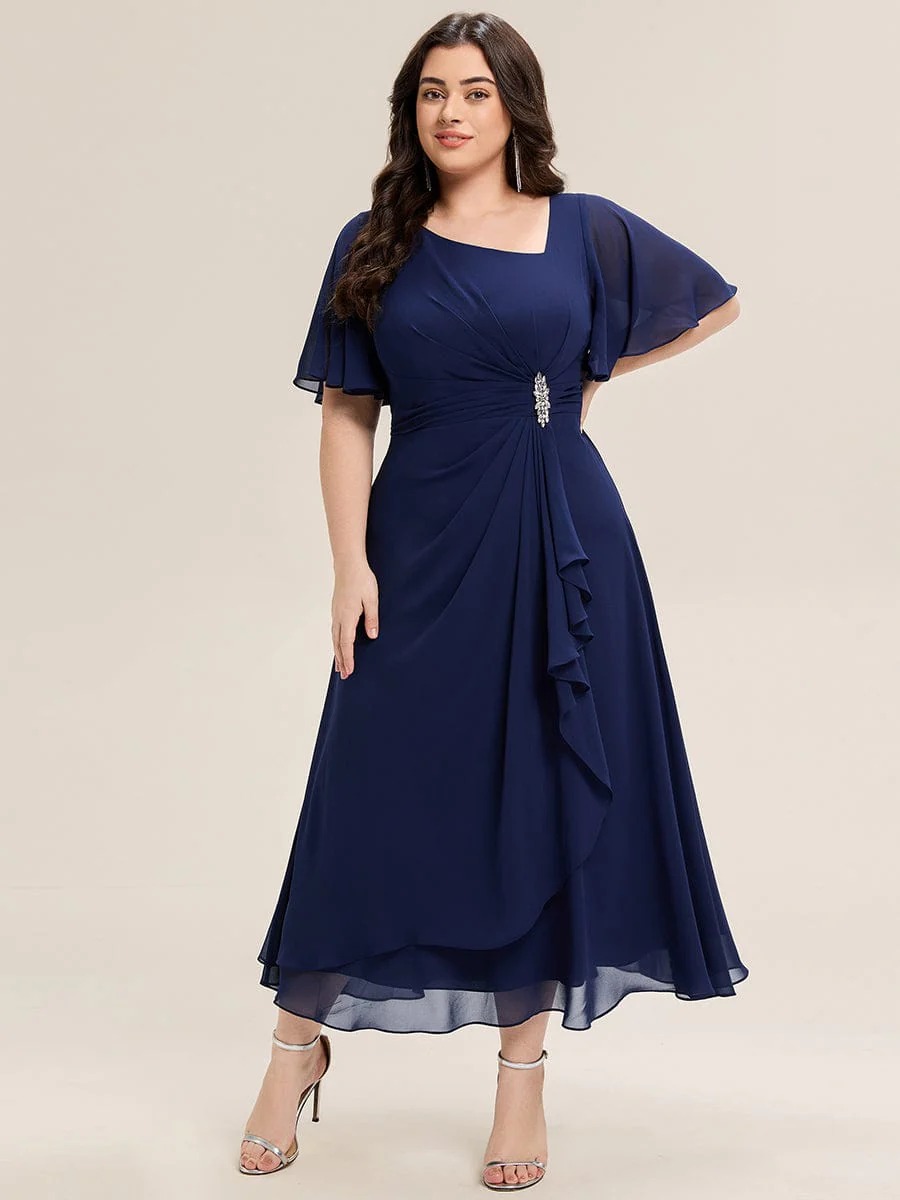 Lilou A beautifully pleated chiffon midi dress designed for plus-size elegance, featuring soft ruffle sleeves and a flattering flowy silhouette — perfect for any special celebration. This dress is not currently in stock but is available to order.