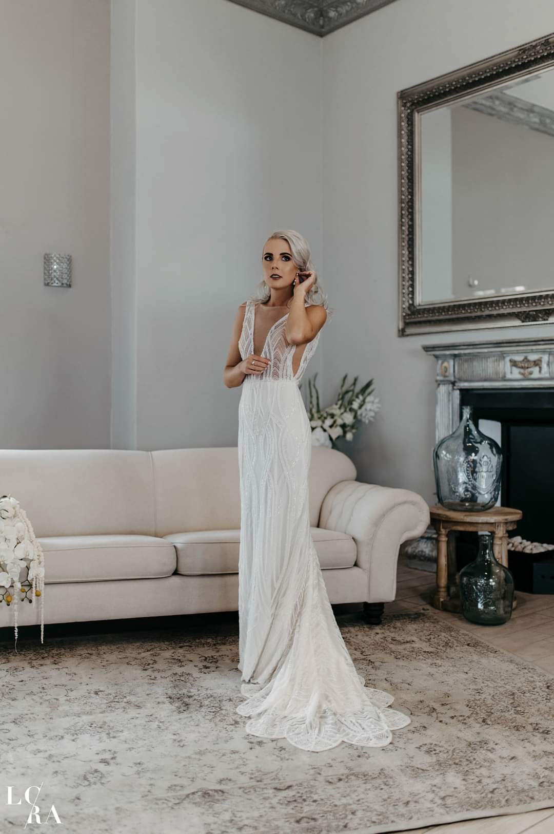 esmare Dazzling Beaded Sequin Lace Sheath Bridal Gown For the bride who loves glamour and sophistication, this stunning beaded sequin lace wedding dress is designed to shimmer with every step. ✨ Design Highlights: ✔ Deep plunging bustline – A bold and elegant statement that enhances the silhouette. ✔ Low open back – Adds a touch of allure and modern elegance. ✔ Illusion inserts under the arms – A unique detail that creates a sleek and seamless look. ✔ Slim-fitted sheath silhouette – Designed to hug the body beautifully, enhancing natural curves. ✔ Short train – Perfect for a graceful yet effortless bridal look. 💫 Customization Options: ✅ Made to measure for the perfect fit. ✅ Available in your preferred colour. ✅ Choose a long or short train to match your vision. ✅ Option for short or long sleeves for added versatility. ✅ Personalize it with or without a slit for a modern or classic touch. 👑 A gown for the bride who wants to sparkle with elegance and confidence. 👑 📞 Custom orders available! 📧 info@bestersbridal.co.za | 📱 084 268 1354