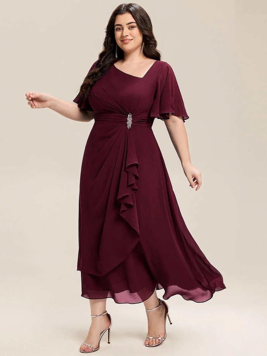 Lilou A beautifully pleated chiffon midi dress designed for plus-size elegance, featuring soft ruffle sleeves and a flattering flowy silhouette — perfect for any special celebration. This dress is not currently in stock but is available to order.