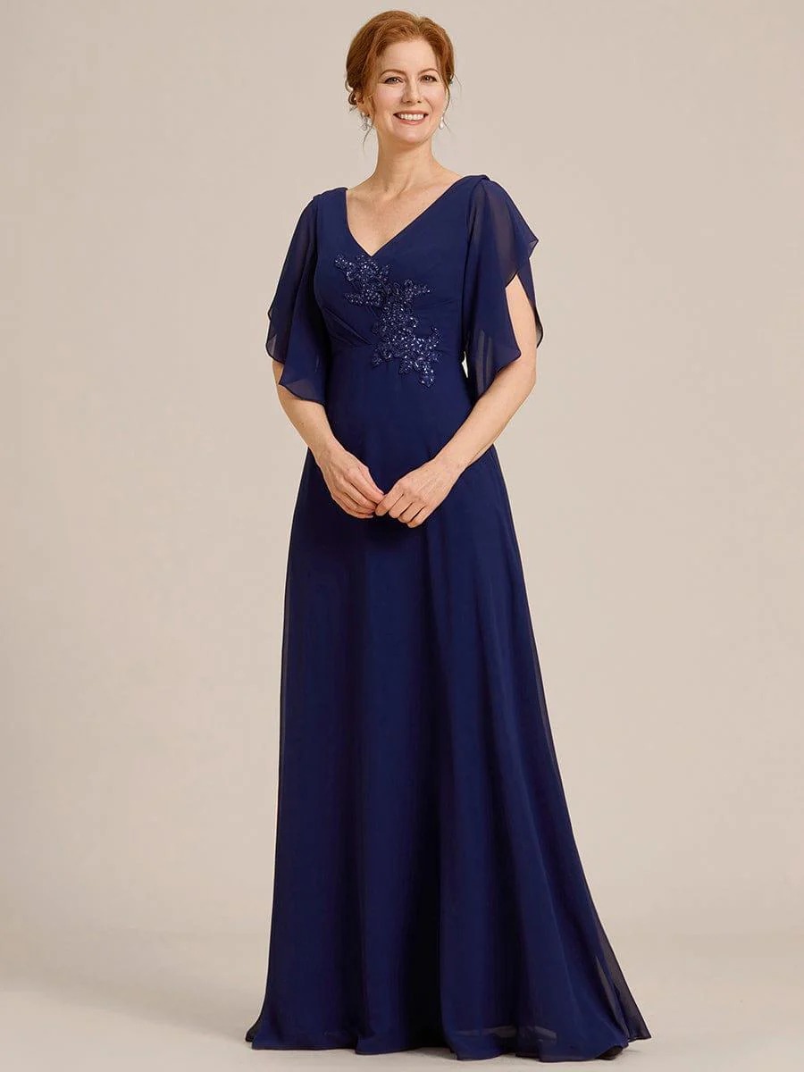 Lorie A graceful chiffon Mother of the Bride dress featuring elegant half sleeves and beautifully placed appliqué detailing on the bodice for a refined and feminine finish. This dress is not currently in stock but is available to order.