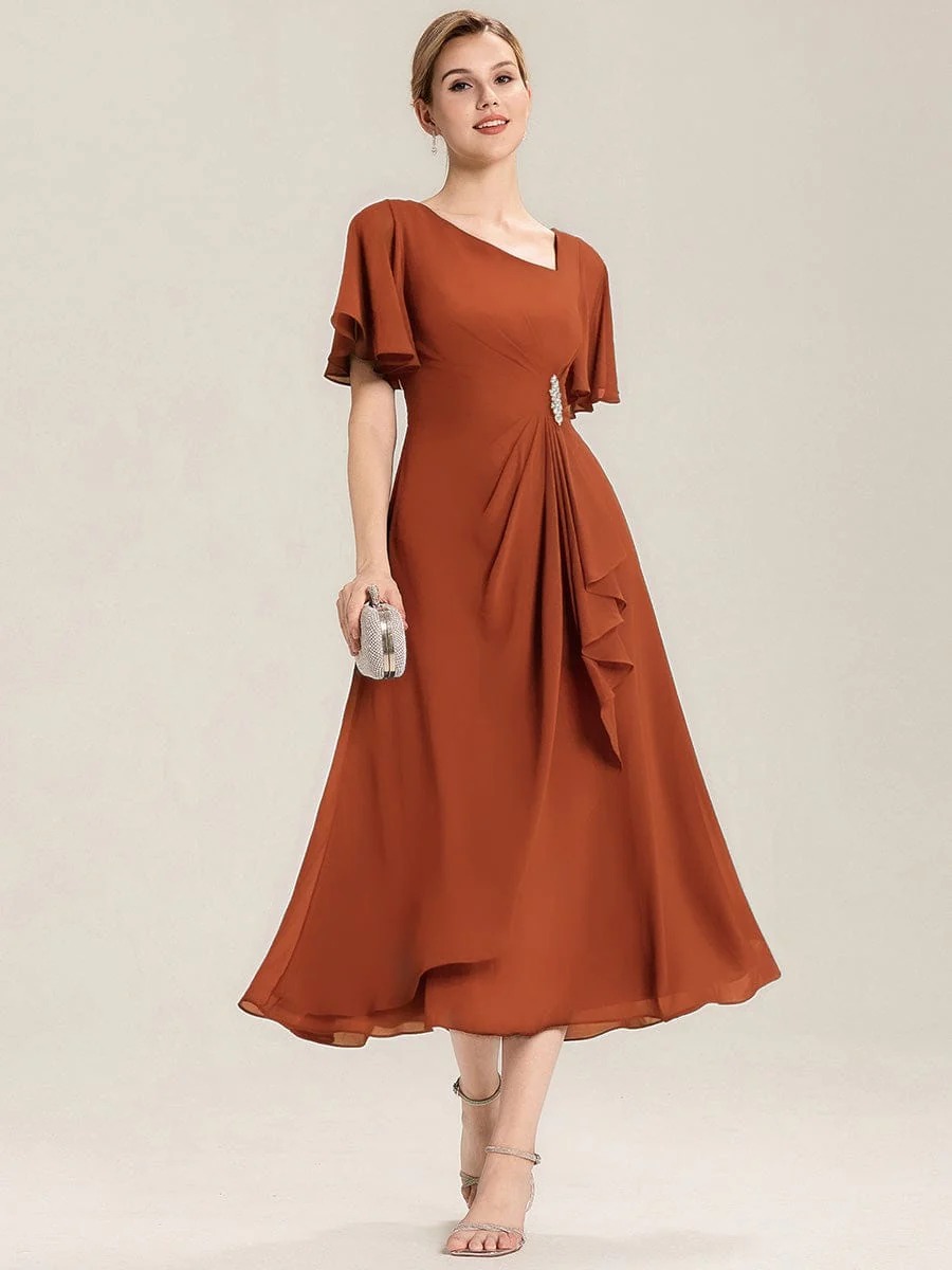 Lilou A beautifully pleated chiffon midi dress designed for plus-size elegance, featuring soft ruffle sleeves and a flattering flowy silhouette — perfect for any special celebration. This dress is not currently in stock but is available to order.
