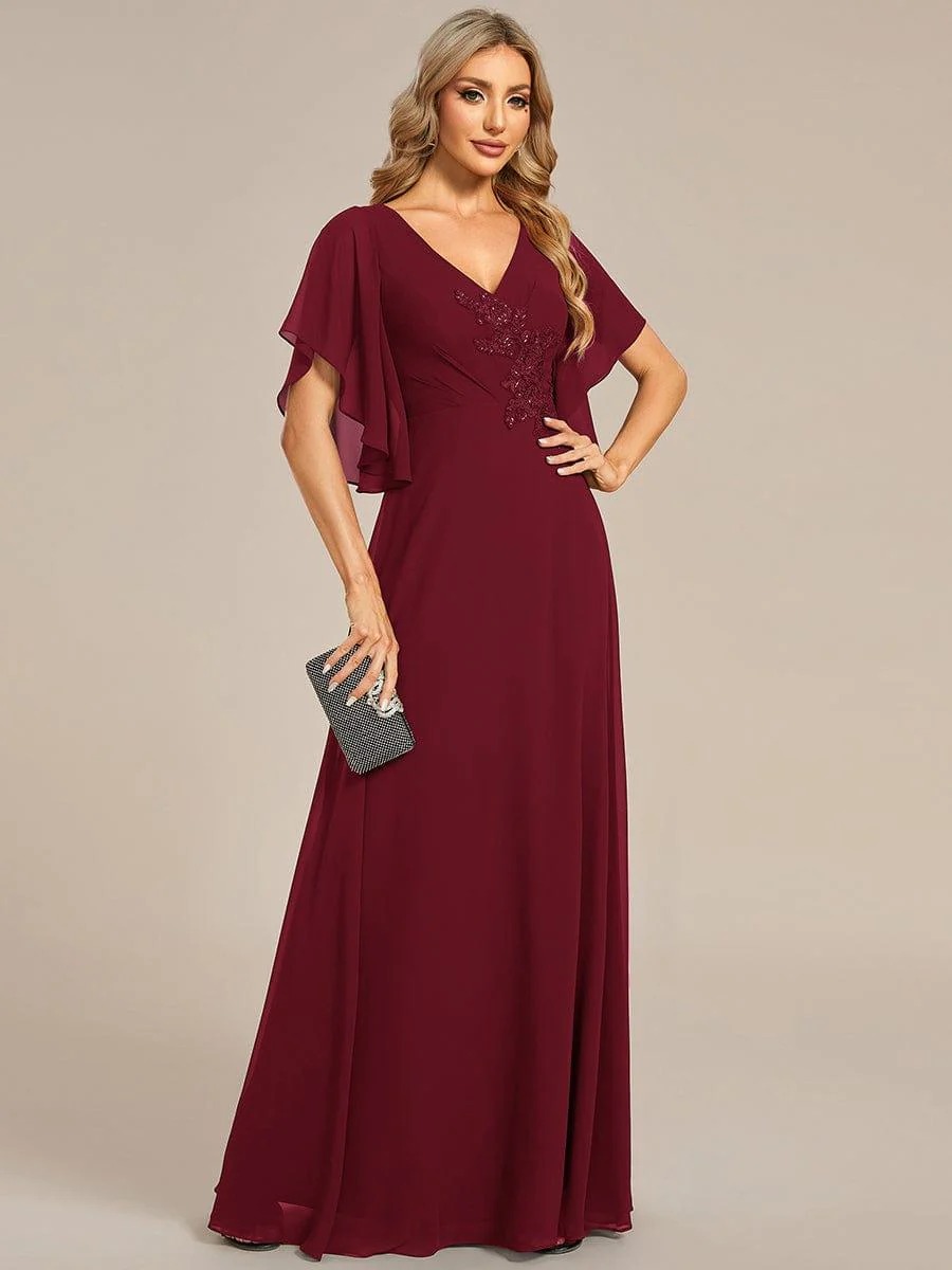 Lorie A graceful chiffon Mother of the Bride dress featuring elegant half sleeves and beautifully placed appliqué detailing on the bodice for a refined and feminine finish. This dress is not currently in stock but is available to order.